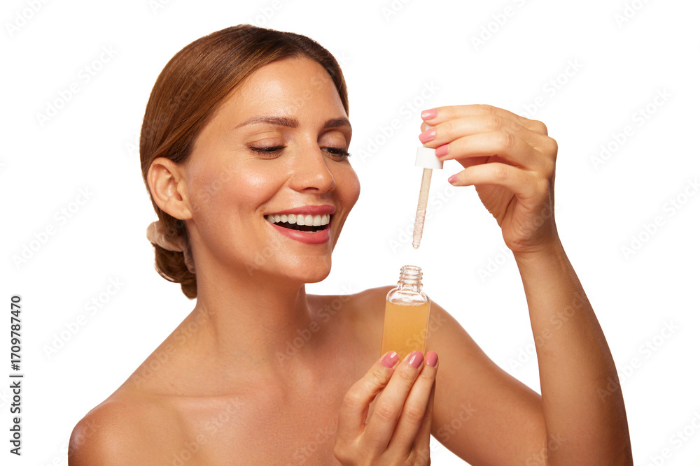 Fototapeta premium A woman smiles as she prepares to apply skin care serum from a dropper bottle. Her glowing skin reflects her enthusiasm for beauty care in a clean, bright environment.