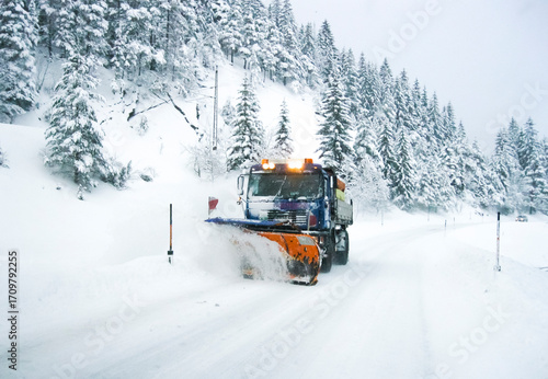 Konstfotografi A snow plow vehicle is driving down a winter snowcovered road