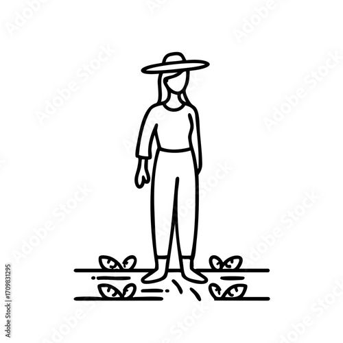 Woman in a hat stands in a field of plants. She is wearing a hat and pants and she is a farmer