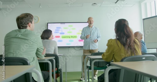 Mature Adult Teacher in front of Interactive Whiteboard in Classroom