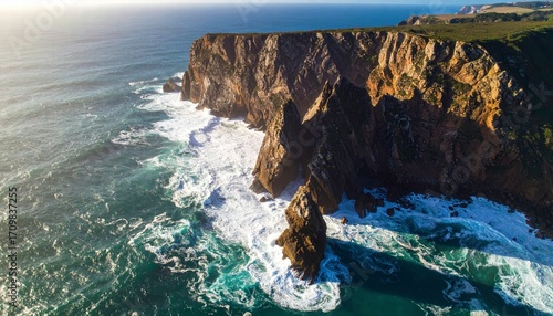 Aerial view of a coastal cliff with waves crashing below
