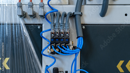 Close-Up of Industrial Pneumatic Solenoid Valves and Blue Tubing