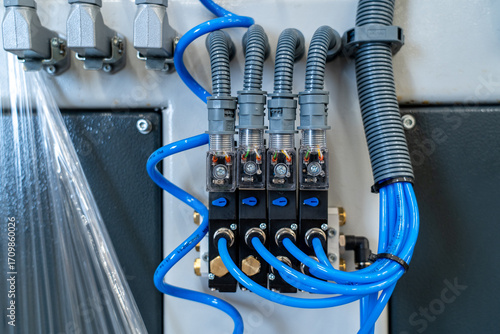 Industrial Pneumatic Valves and Blue Tubing in Factory Control Panel