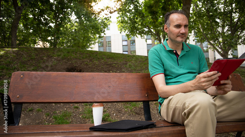 Man sitting outdoors with tablet