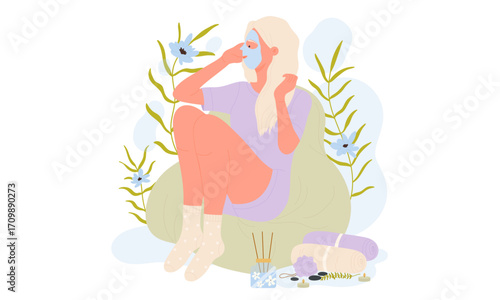 Woman with face mask sitting on a beanbag chair surrounded by plants.