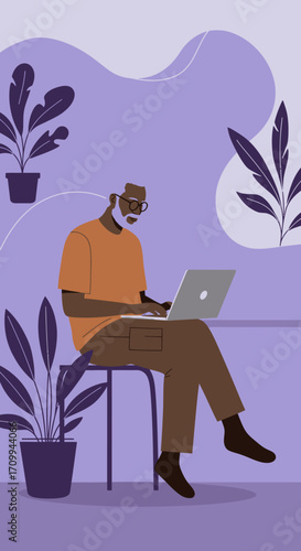 Senior Black man with glasses and a beard works on a laptop in a cozy, plant-filled modern home office, highlighting digital literacy and remote lifestyle.