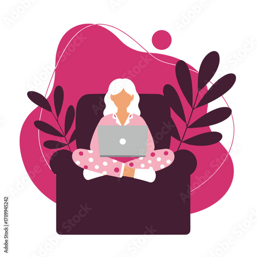 A comfortable woman in pajamas is diligently working on her laptop from the cozy confines of her armchair at home, embracing the flexibility of remote work.