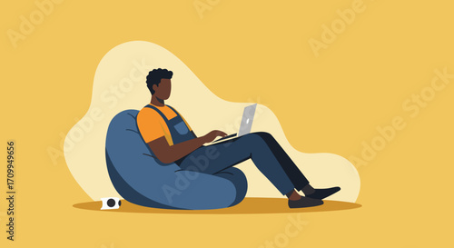 Professional African American businessman focused on his laptop while working remotely or in a modern office setup. Emphasizes technology and productivity.