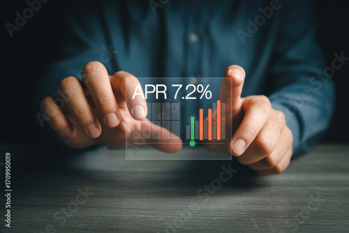 Man holding transparent screen showing apr 72 percent and growth chart