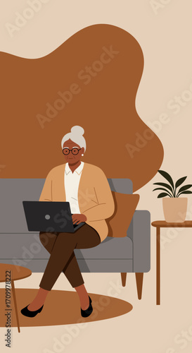 Senior Black woman comfortably using a laptop on a sofa at home, representing modern lifestyle, online connectivity, and independent living.