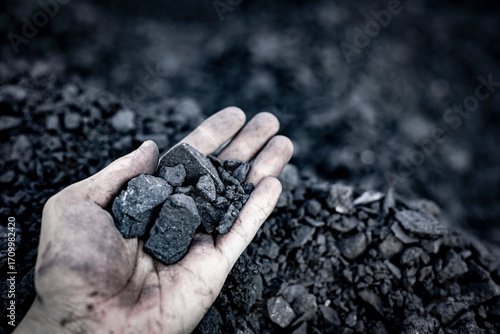 Black coal in hand. Thermal energy industry. Heating. Mineral raw materials. Natural energy stones.