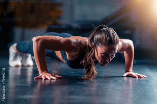 Fotografía Performing push ups in the gym, a woman builds upper body strength and endurance