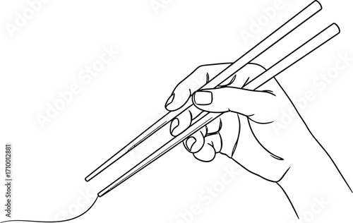 Close-up of a hand holding chopsticks to pick up noodles, illustrating culinary tradition.