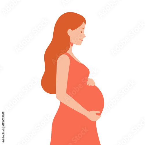 Beautiful pregnant woman with long flowing red hair holding her belly in a simple orange dress