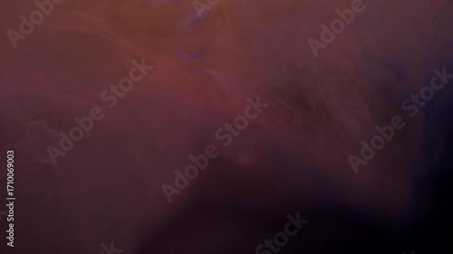 Slow motion orange and pink ink acrylic paint mixing in water, swirling softly underwater. Acrylic cloud paint in aquarium. Slowmotion abstract smoke explosion animation. Beautiful art background