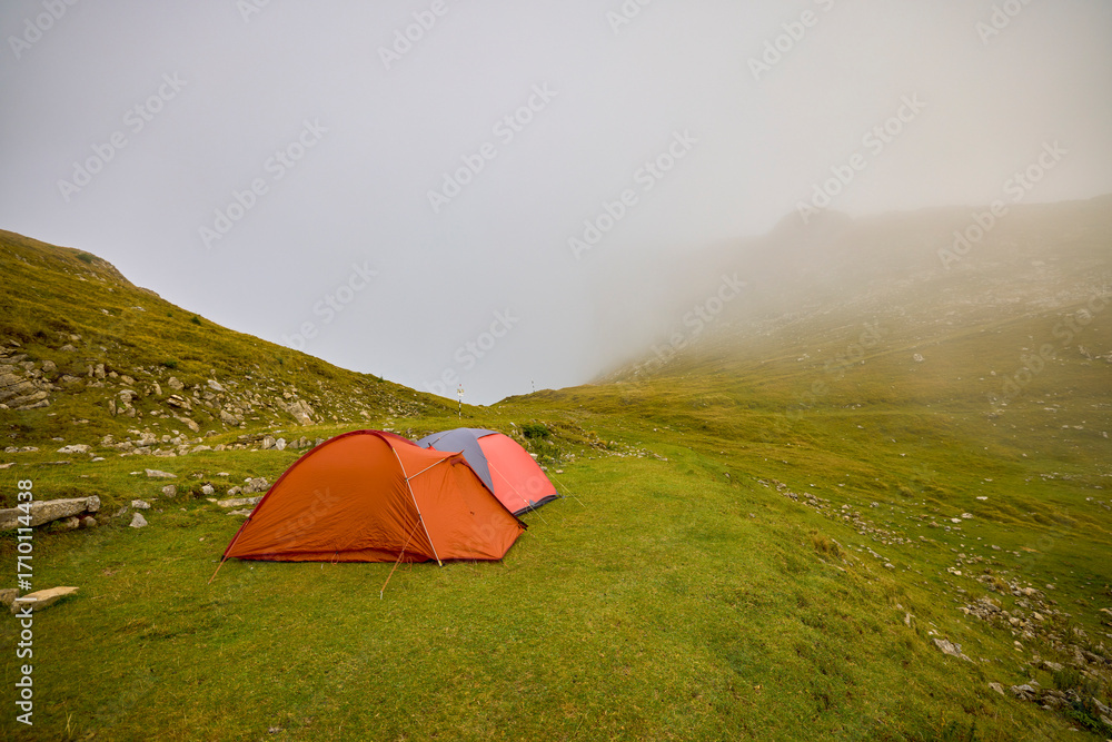 Obraz premium two tents camped in a mountain landscape on a foggy day
