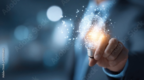 Close up of a hand holding a light bulb with digital connections, symbolizing innovation and creative ideas