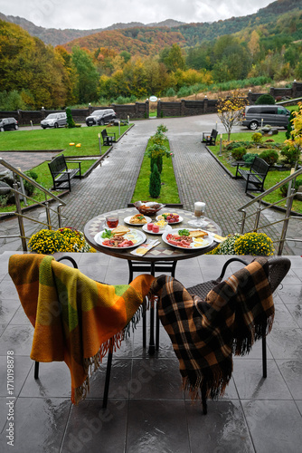 Breakfast table set outdoors with a scenic view of the mountains and fall foliage.