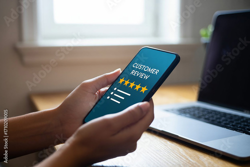Hands holding smartphone displaying customer review with stars