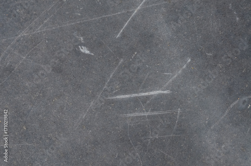 Foto This detailed photograph captures the imperfection of a dark gray texture, marked by numerous scratches and scuffs, conveying a sense of history and decay