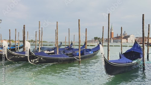 Gondolas on the Grand canal near San Marco square in Venice, Italy. San Giorgio Maggiore Cathedral in the background. Cityscape at sunset. Famous travel destination.
