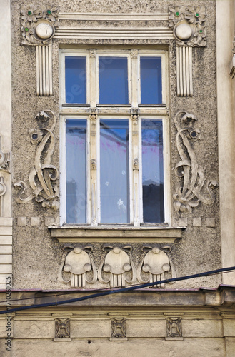 Eleganckie okno w stylu secesyjnym w zabytkowym budynku  z misternymi detalami kwiatowymi i rze  biarskimi. 