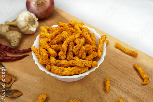 Bowl of home made potato chips made with rice, mustard, rosemary, fleur, salt, onion and chili on white background. Indian tea snacks, namkeen concepts. Top view. Copy space