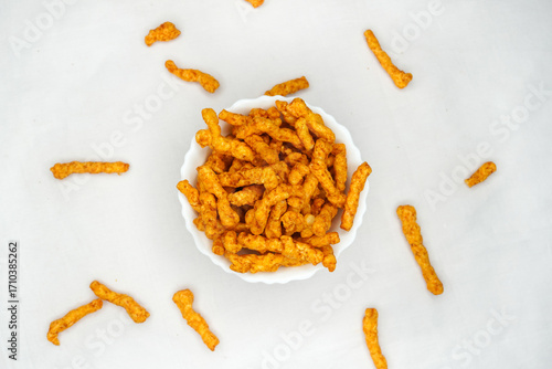 Delicious India favorite snack kurkure crunchy corn sticks, on white background. Indian tea snacks concepts.