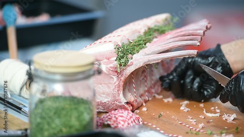 Butcher seasoning pork chops with rosemary before cooking
