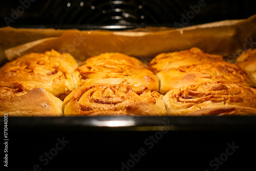Fotografie Freshly baked cinnamon rolls in oven tray