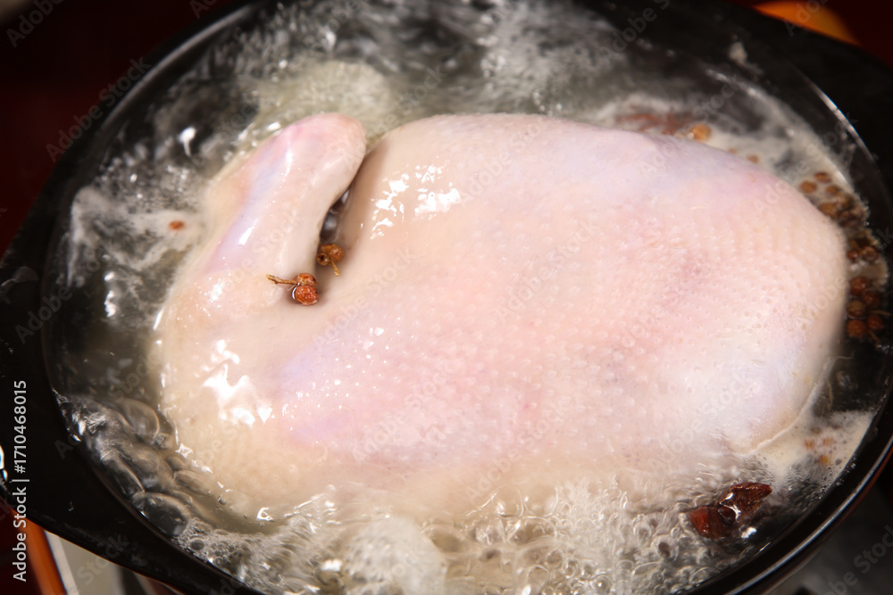 Fototapeta premium Raw Whole Chicken Breasts Boiling in Water with Spices - Fresh Farm Poultry Cooking