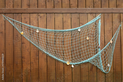 fishing net with shells hanging on wood wall