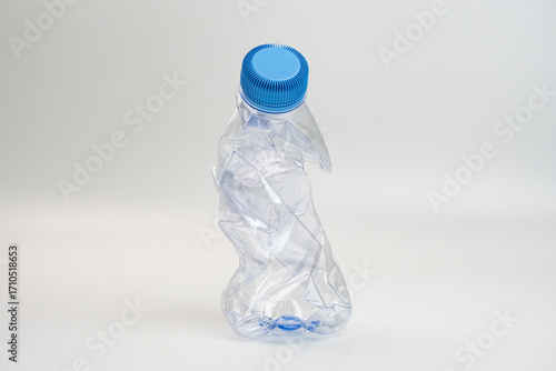 One crumpled plastic bottle isolated on white. Environmental conservation concept by not using plastic bottles. Environmental care movement from plastic waste.