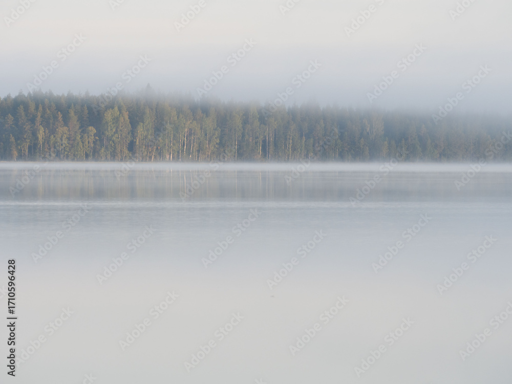Fototapeta premium Calm lake, morning fog, clear sky, forest on the horizon. Republic of Karelia, northwest Russia