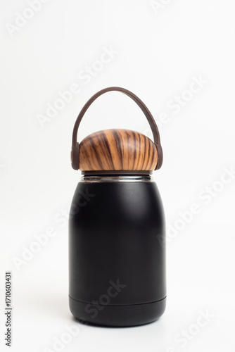 A black stainless steel bottle with a wood-patterned cap on a white background. A compact, eco-friendly, heat-resistant bottle concept. An isolated bottle mockup.