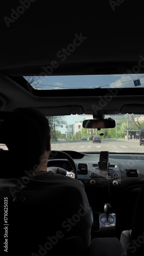 Passenger POV of a driver on a sunny urban road trip. Vertical Video