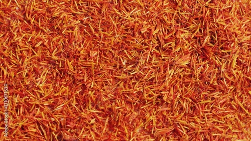 Dried crimson saffron on grey desk close-up macro. Orange red spice for food. Crocus sativus flower saffron