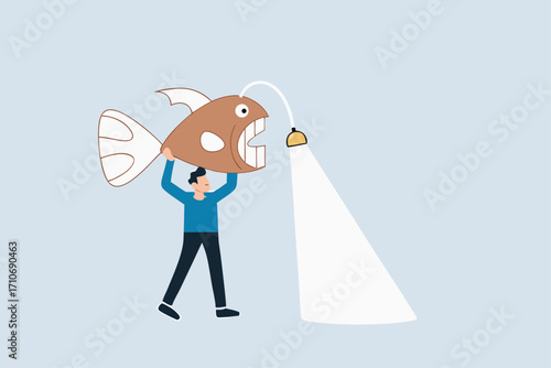 Business direction, businessman carries angler fish as torch to guide way