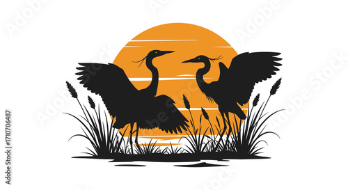 Silhouetted cranes against a vibrant orange sunset with marsh vegetation