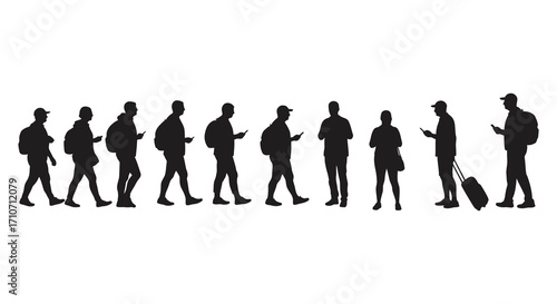 A row of silhouetted people walking many using their mobile phones