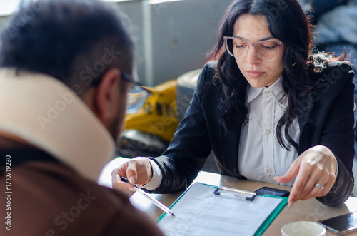 Young lawyer showing a document paper to a male client, insurance, legal contract or lawyer consulting. Disability people, attorney or advocate in negotiation, policy advice or accident report