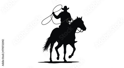Silhouette of a cowboy on horseback swinging a lasso in motion