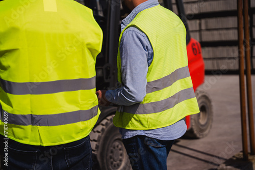 Engineers from back overseeing construction site progress. Control safety on contruction site.