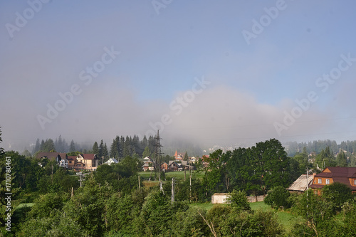 fog in the mountains houses at altitude green forest summer