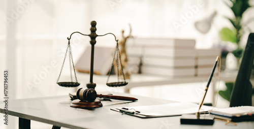law firm courtroom Law books, computer and scales of justice on table in lawyer office