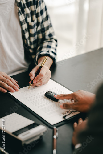 Portrait of a car sales contract signing, a broker advising a client on signing or refinancing a car.