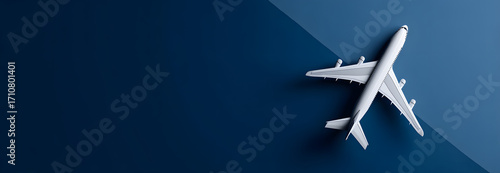 Overhead View of a White Passenger Airplane Model on a Modern Two-Tone Blue Background, Symbolizing Global Travel and Aviation