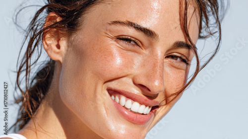 closeup of woman face featuring radiant skin and joyful smile after intense workout