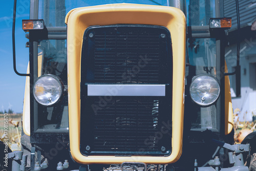 Closeup front view of a vintage farm tractor.