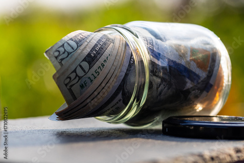 US dollar banknote saving money in glass jar. Consumption and economy
